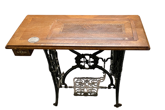 1 TAVOLINO REALIZZATO CON PIANO IN LEGNO E BASE IN GHISA DI UNA VECCHIA MACCHINA DA CUCIRE A PEDALE (SEIDEL & NAUMANN, DRESDEN) DIM. 83x76x45 CM
