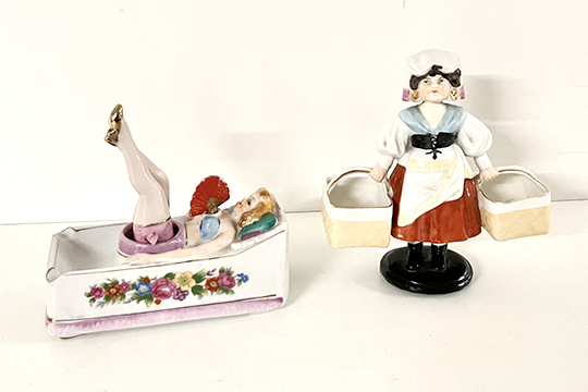 2 PORCELLANE SEMOVENTI: 1 POSACENERE VASCA DA BAGNO CON “PIN-UP GIRL” (GAMBE E VENTAGLIO MOBILI) E 1 RAGAZZA CON CESTINI CHE DONDOLA DIM. 14x13x7 E 13x15x6 CM
