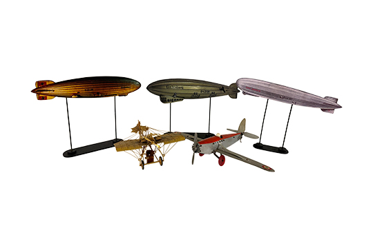 3 MODELLINI “DIRIGIBILE” IN LEGNO FINEMENTE DIPINTO CON SUPPORTO DA ESPOSIZIONE E 2 MODELLINI “AEREO” IN METALLO ANCHE DORATO (PICCOLI DIFETTI)